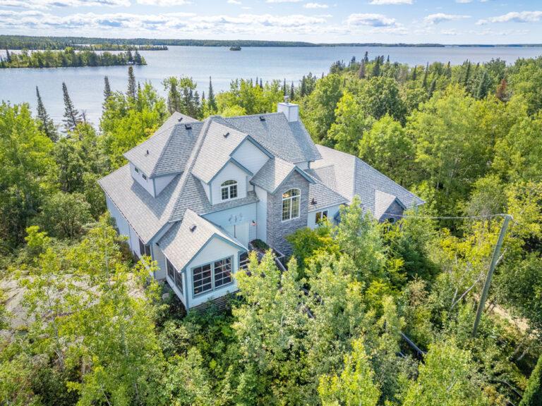 Aerial view of 1416 11 Grassington with lakeside home, surrounding trees, and waterfront scenery