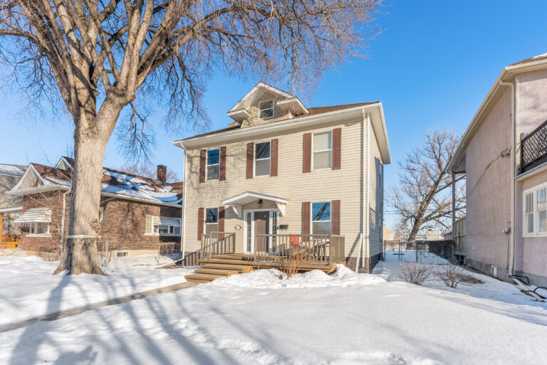 Exterior view of 1663 630 St Jean Baptiste Street with front porch, snow-covered yard, and clear blue sky