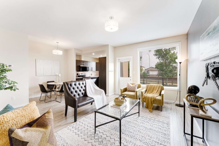 Living room at 805-1355 Lee Boulevard with open dining area, kitchen view, large window, and staged seating