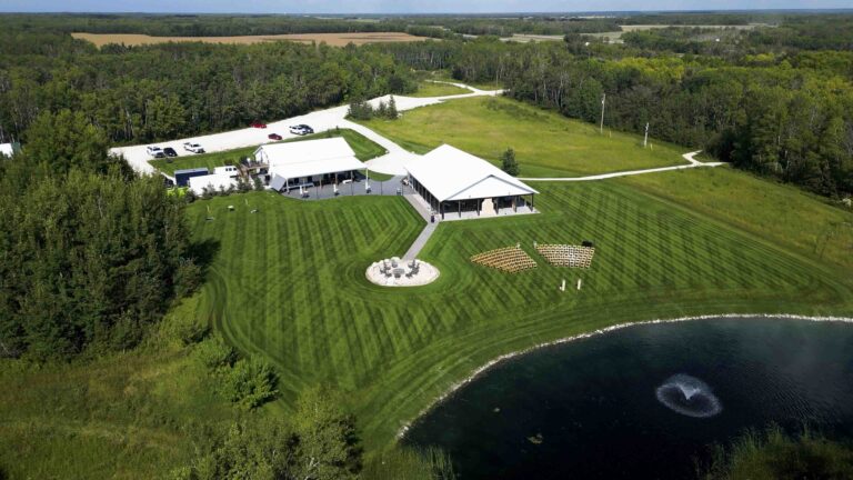 Aerial view of a countryside wedding venue with pond and outdoor ceremony seating