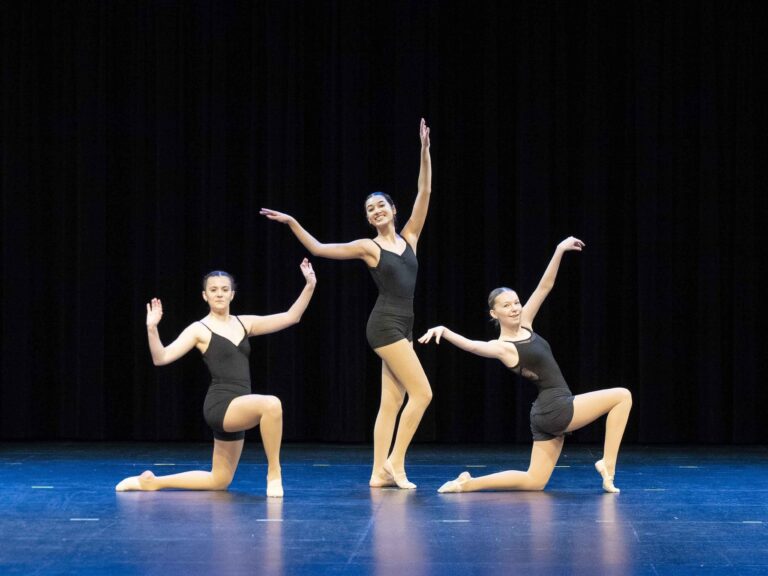 Three dancers performing on stage during a Winnipeg recital