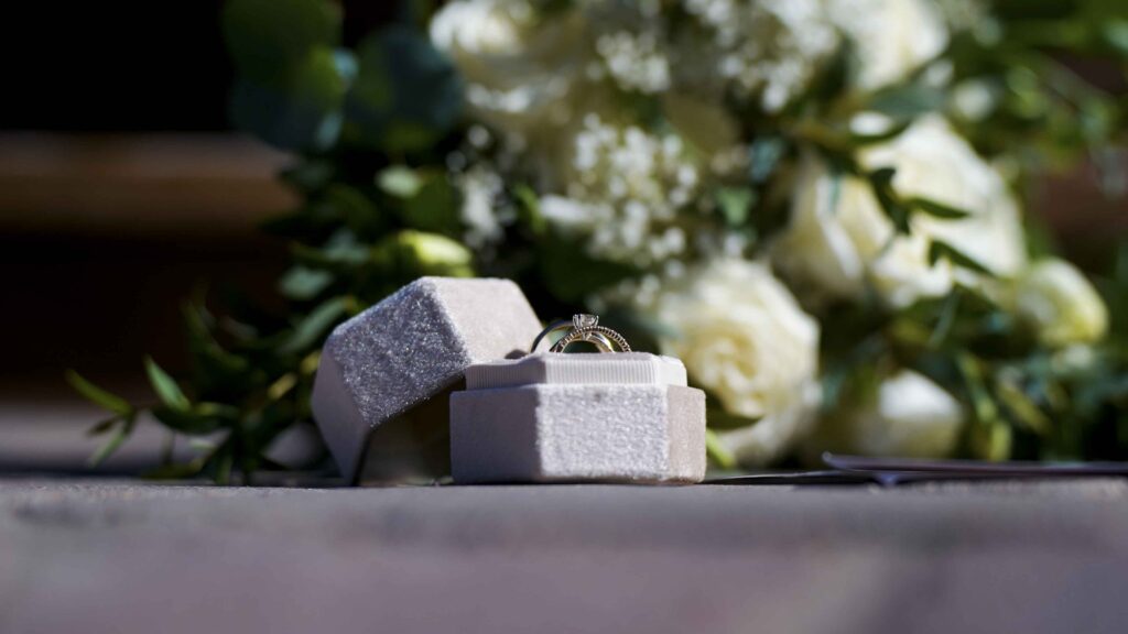 Wedding rings in a velvet box with white floral bouquet for a Manitoba wedding