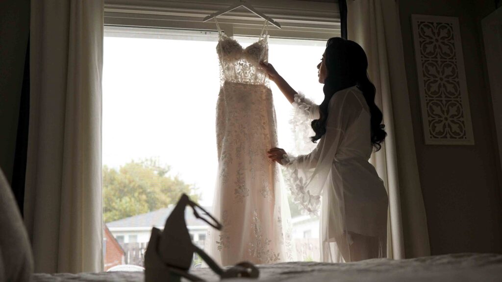 Wedding dress hanging by Bride