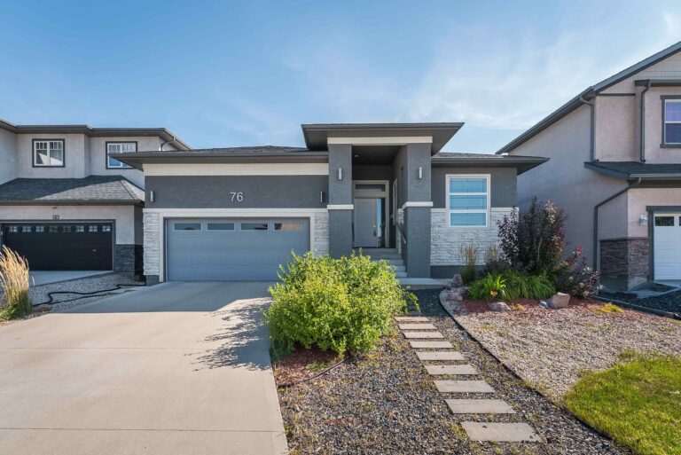 Modern home exterior with driveway, garage, and landscaped front yard