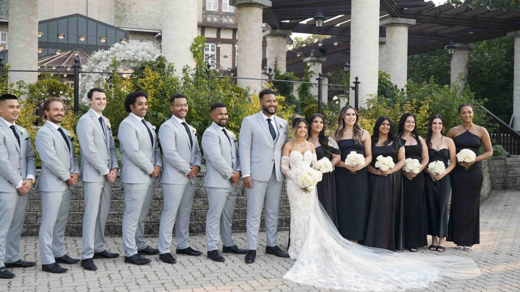 Wedding party group photo with bride, groom, groomsmen, and bridesmaids at an outdoor venue