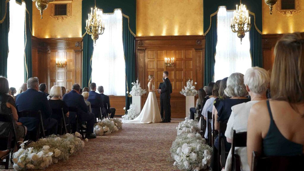 Indoor wedding ceremony with couple exchanging vows in front of seated guests